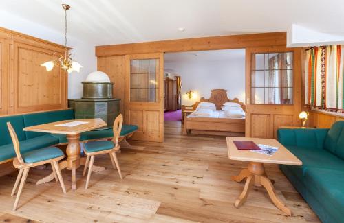 een woonkamer met een blauwe bank en een tafel bij Hotel Seelaus in Alpe di Siusi