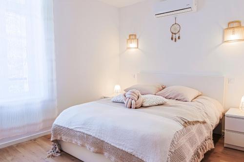 - une chambre blanche avec un lit et des draps blancs dans l'établissement Maison T3 2CH - Les Volets Bleus, à Lapalme