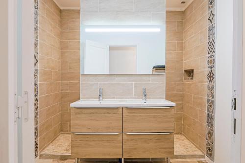 une salle de bain avec un lavabo et un miroir dans l'établissement Maison T3 2CH - Les Volets Bleus, à Lapalme