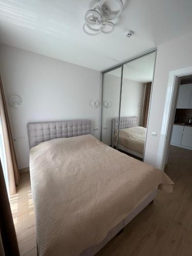 a bedroom with a bed and a mirror at ЖК «Сонячний квартал» in Solochin