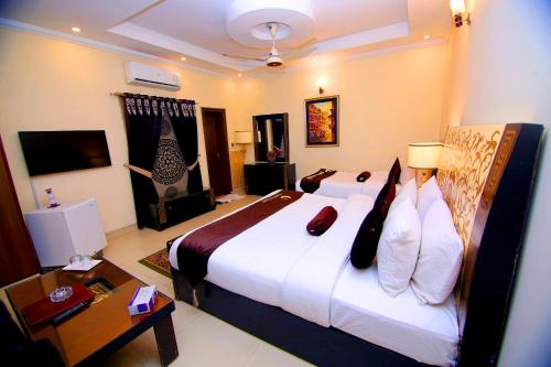 a hotel room with a large bed and a desk at Premier Inn Grand Gulberg Lahore in Lahore