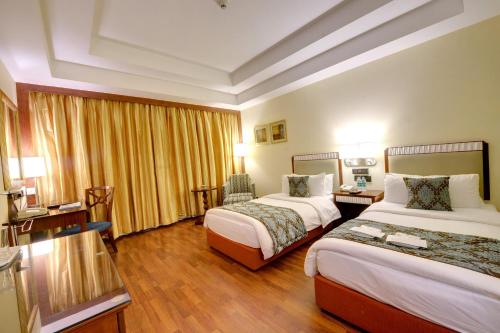 a hotel room with two beds and a desk at Fortune Select JP Cosmos, Bengaluru - Member ITC Hotels' Group in Bengaluru
