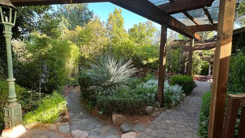 a garden with a pergola and a plant at Lantern Light Inn - Romantic Getaway in Sedona