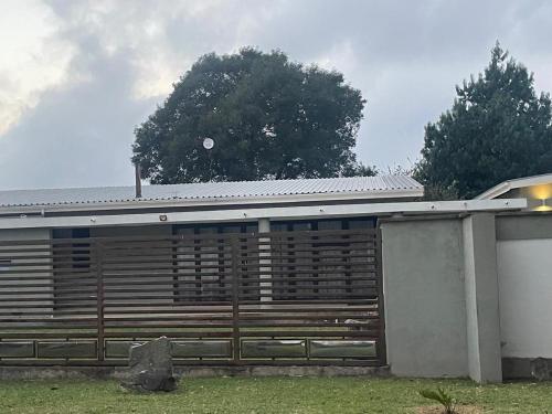 a house with a wooden fence in front of it at StoneWall Villa in Mbabane