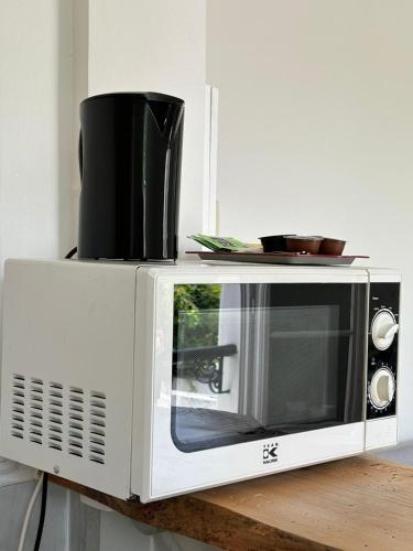 Un four micro-ondes est installé au-dessus d'une table en bois. dans l'établissement Appartement 2 pièces, à Asnières-sur-Seine