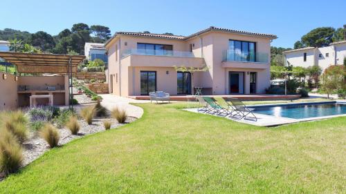 une maison avec une piscine dans une cour dans l'établissement Villa Seabel - le standing avec piscine et vue mer, à Hyères