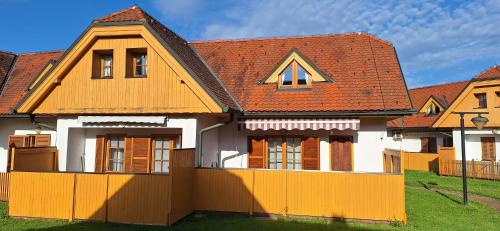 a house with a fence in front of it at Apartments Prekmurska vas - Vital Resort in Moravske Toplice
