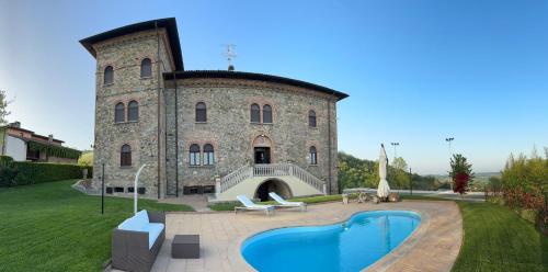a large stone building with a pool in front of it at Tenuta Il Poggio - Luxury B&B in Felegara