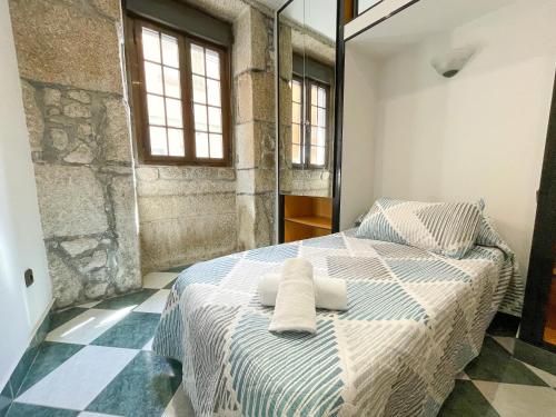 a bedroom with a bed with two towels on it at Apartamentos Illa de Arousa Centro 3000 in Isla de Arosa