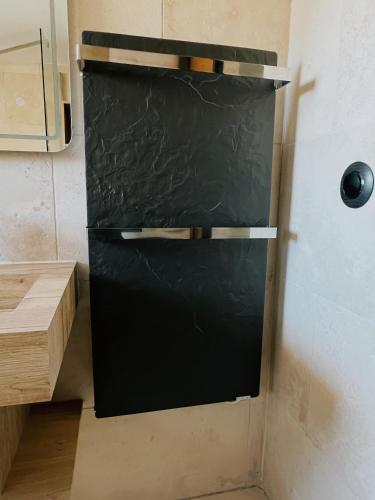 a black refrigerator in the corner of a kitchen at Domus Via Domitia in Narbonne