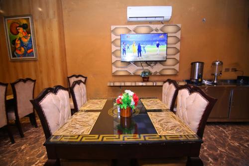 a dining room with a table and a television at Premier Inn Grand Gulberg Lahore in Lahore
