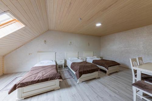 a room with three beds and a table and a window at Premium hotel & SPA in Bukovel
