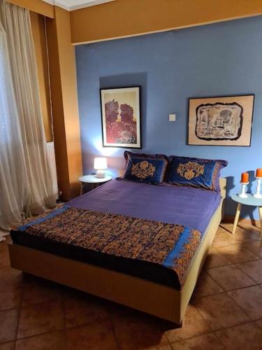 a bedroom with a bed with a blue wall at Όμορφο, άνετο ζεστά διακοσμημένο διαμέρισμα in Thérmi