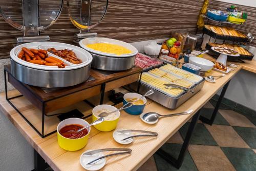 un tavolo con un po' di cibo sopra con cucchiai e piatti di Hotel Garni Na Havlíčku a Kutná Hora