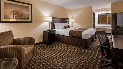 Best Western PLUS Inn of Hayward في هايوارد: غرفة فندق بسرير وتلفزيون