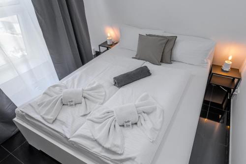 Una cama blanca con dos corbatas de lazo. en Nibelungen Apartments en Worms