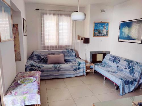 a bedroom with a bed and a couch and a table at Villa Favignana in Favignana