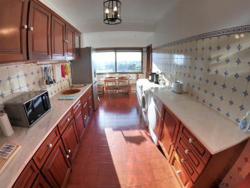a kitchen with wooden cabinets and a counter top at Lisbon T2 apartment in condominium in Linda-a-Velha Oeiras Lisbon in Linda-a-Velha