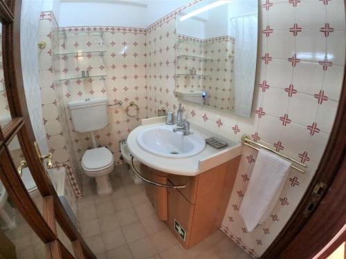 a bathroom with a sink and a toilet and a mirror at Lisbon T2 apartment in condominium in Linda-a-Velha Oeiras Lisbon in Linda-a-Velha