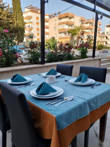 stół z niebieską tkaniną stołową i sztućcami w obiekcie BALŞEN HOTEL w mieście Anamur