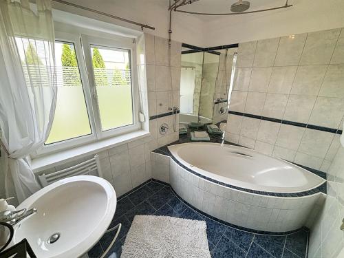een witte badkamer met een bad en een wastafel bij Haus Sunnseitn in Innsbruck