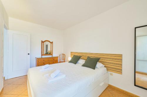 Un dormitorio con una cama blanca con dos toallas encima. en Benalbeach playa - Tu hogar frente al mar, complejo 4 piscinas, en Arroyo de la Miel