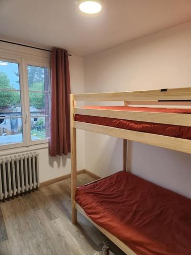 une chambre avec deux lits superposés et une fenêtre dans l'établissement Marmoza - Maison plein cœur de village, à Saint-Geniez-dʼOlt