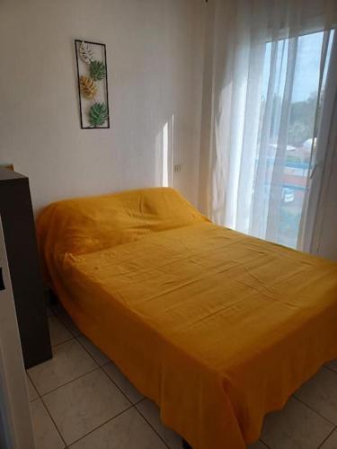 Cette chambre comprend un lit avec un couvre-lit orange. dans l'établissement T2 climatisé front de mer avec terrasse et parking - V0742, à Vias