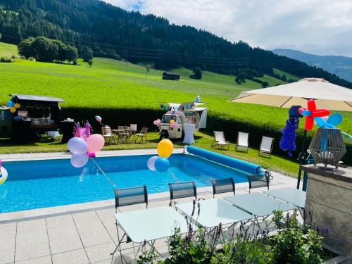 a swimming pool with balloons next to a house at KreativhausTirol in Weerberg