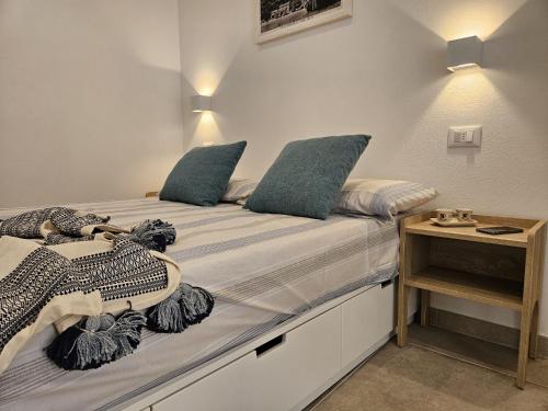 a bedroom with a bed with blue pillows on it at Joivy Dimore Rodiane - U Vucc'l in Rodi Garganico