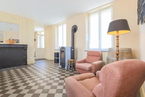 un salon avec deux chaises et une cheminée dans l'établissement La ferme des Pommés, à Pommera