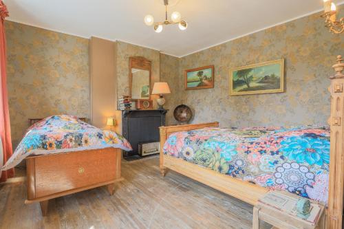 a bedroom with two beds and a mirror at La ferme des Pommés in Pommera