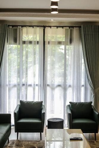 a living room with two couches and a large window at Iris Lakeside Condos in Entebbe in Entebbe