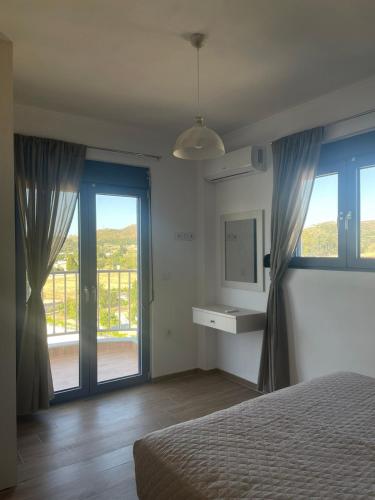a bedroom with a bed and a large window at PARASCHOS APARTMENTS Kardamaina in Kos