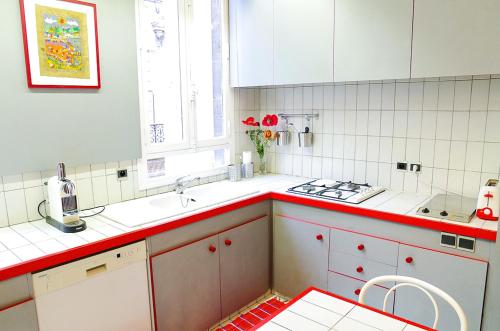 une cuisine avec des placards blancs et des comptoirs rouges dans l'établissement Trois Conils - Localisation exceptionnelle 3 chambres 3 salles de bain Parking, à Bordeaux