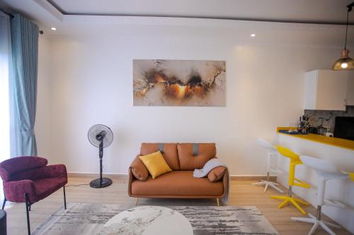 a living room with a brown couch and chairs at Iris Lakeside Condos in Entebbe in Entebbe
