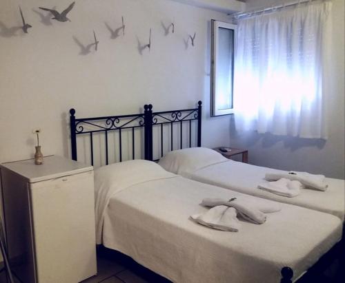 two beds in a bedroom with birds on the wall at Oikeion in Ermoupoli