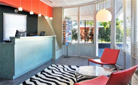 a lobby with a counter and red chairs and a table at Blue Marlin Motel in Key West
