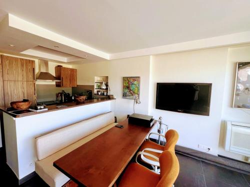 - un salon avec une table à manger et une télévision dans l'établissement Terrasse vue mer, Saint-Tropez, à Saint-Tropez