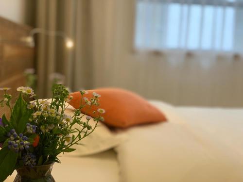 a vase of flowers on a table with a couch at Zhangjiajie One Art Guesthouse in Zhangjiajie