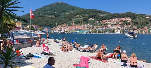 a group of people on a beach near the water at Appartamento con posteggio privato in Portovenere