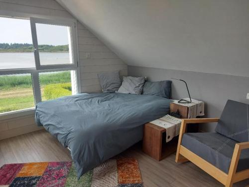 une chambre avec un lit, une chaise et une fenêtre dans l'établissement Villa de vacances au bord de mer, à l'Île-Tudy