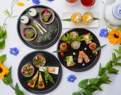 tres platos de comida en una mesa con flores en The One Five Garden Kurashiki - Vacation STAY 96305v en Kurashiki