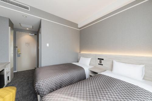 ein Hotelzimmer mit 2 Betten und einem TV in der Unterkunft The One Five Garden Kurashiki - Vacation STAY 96305v in Kurashiki