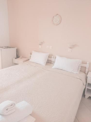 a white bedroom with a bed with two towels on it at Hotel Maria in Skala Potamias