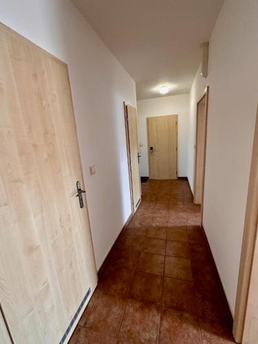 an empty hallway with two doors and a tile floor at Penzion Piller in Chvalín