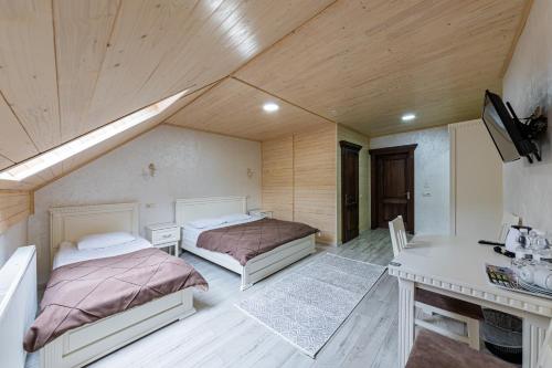 a bedroom with two beds and a table and a desk at Premium hotel & SPA in Bukovel