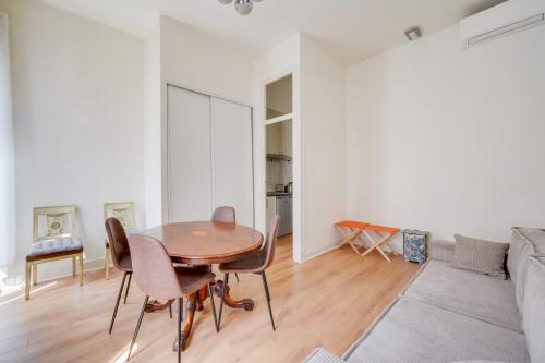 une salle à manger avec une table, des chaises et un canapé dans l'établissement Bel appartement proche Victoire, à Bordeaux