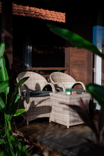 two wicker chairs sitting on a porch at D'Puncak Villas Lembongan in Nusa Lembongan
