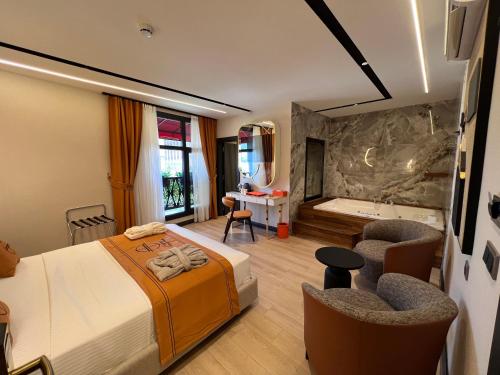 una camera d'albergo con un letto e una vasca da bagno di Elysian Airport Hotel a Arnavutköy